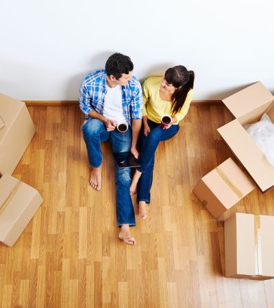 man and woman sitting on floor with moving boxes