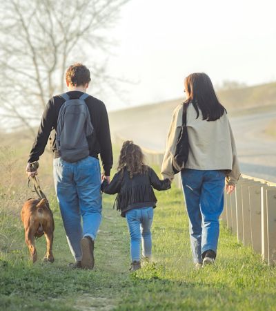 family travels with a small child and a dog, they walk along the road