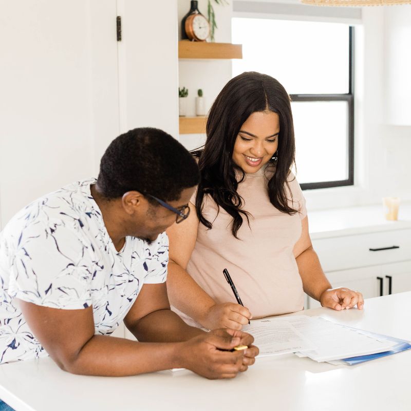 woman and man signing paperwork